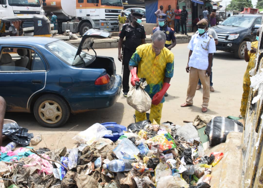 Image result for Man Packs Refuse Into His Car, After Been Caught For Illegal Dumping Of Refuse In Lagos